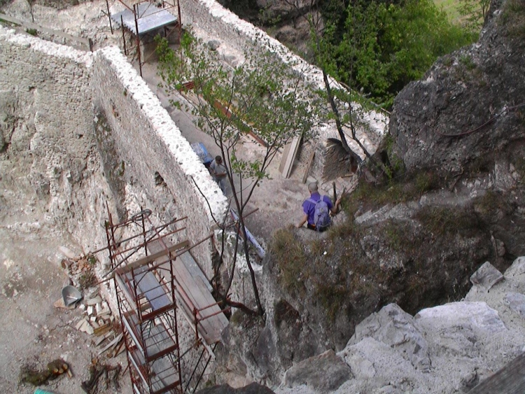 Dalle scalette che portano alle torri un uomo scende verso il camminamento sopra il cortile.