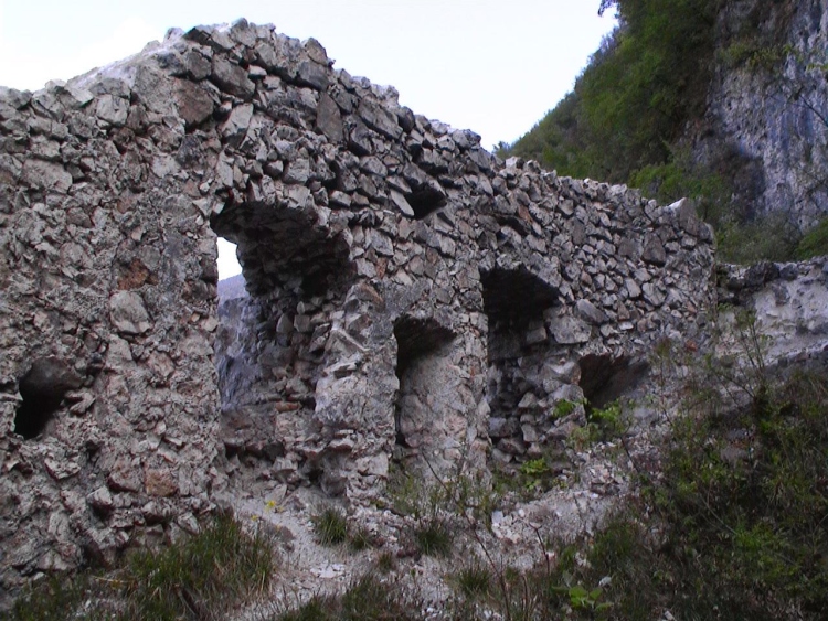 Un pezzo di muro con finestre nella zona dietro il castello. Siamo vicini alla montagna.