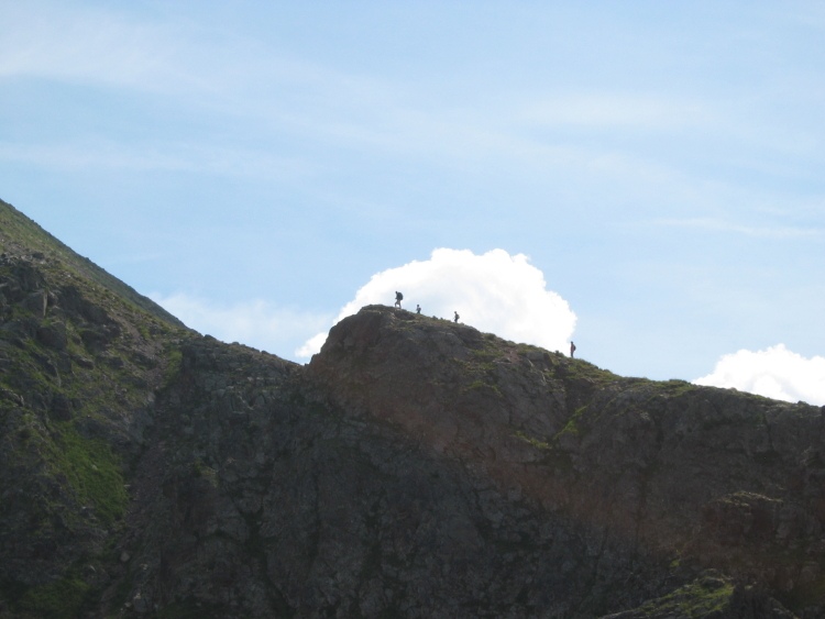 Sul pendio verso il Ziolera vediamo alcuni escursionisti. Dietro il cielo e le nuvole.