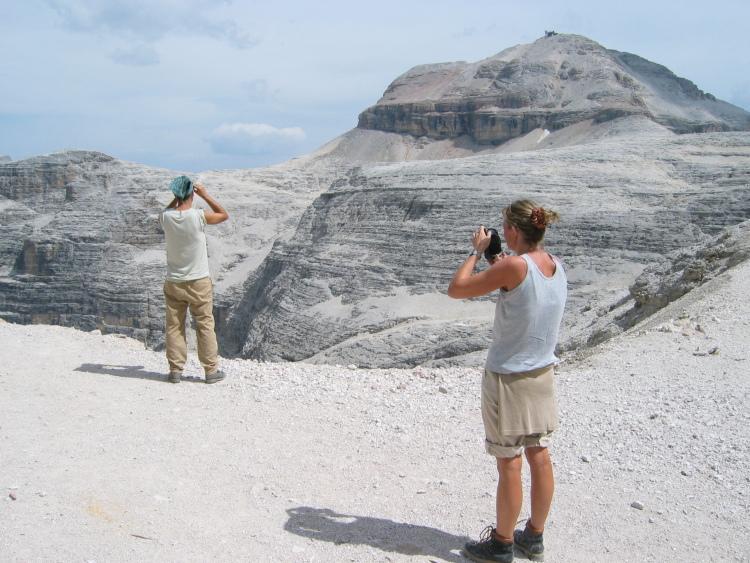 Un amico guarda verso il Piz Boè. La sua ragazza lo fotografa nel paesaggio.