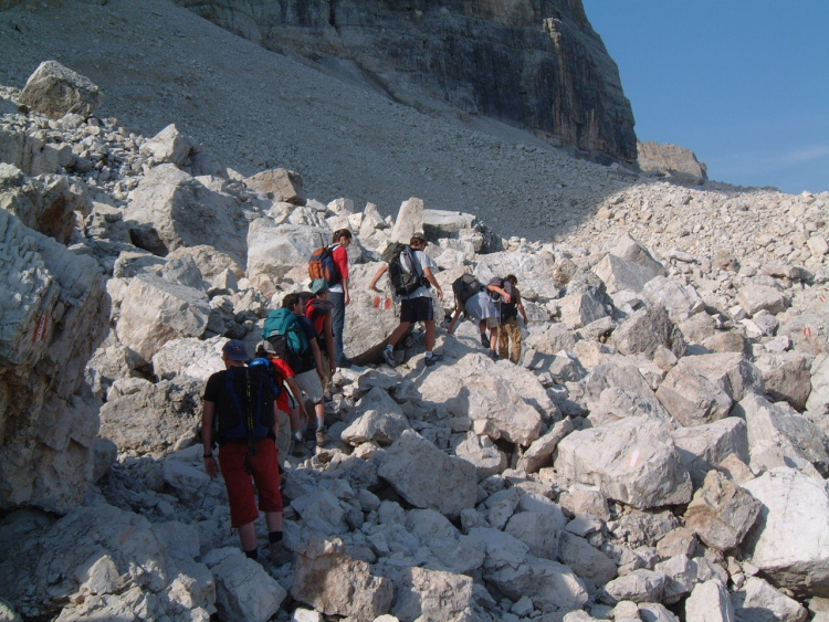 Il primo tratto del sentiero passa tra grossi massi bianchi. Siamo tutti in fila.