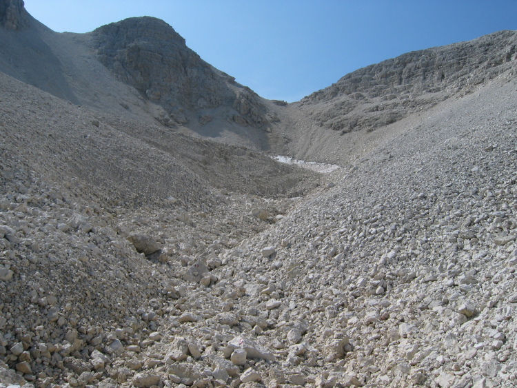 Guardiamo in sù, in una valle completamente coperta di sassi bianchi. Sarà faticoso e lungo salire fino in cima.