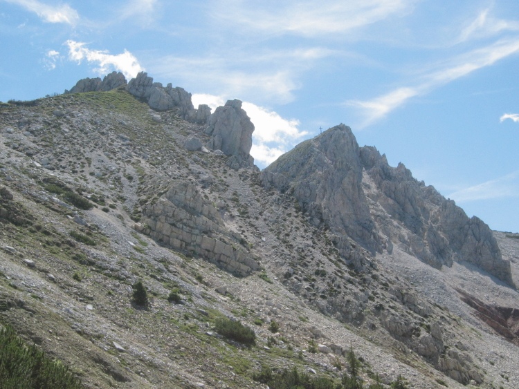 Abbiamo attraversato la parte pericolosa. Vediamo ora la croce del Corno Bianco e a sinistra gli spuntoni di roccia a cui giungeremo.